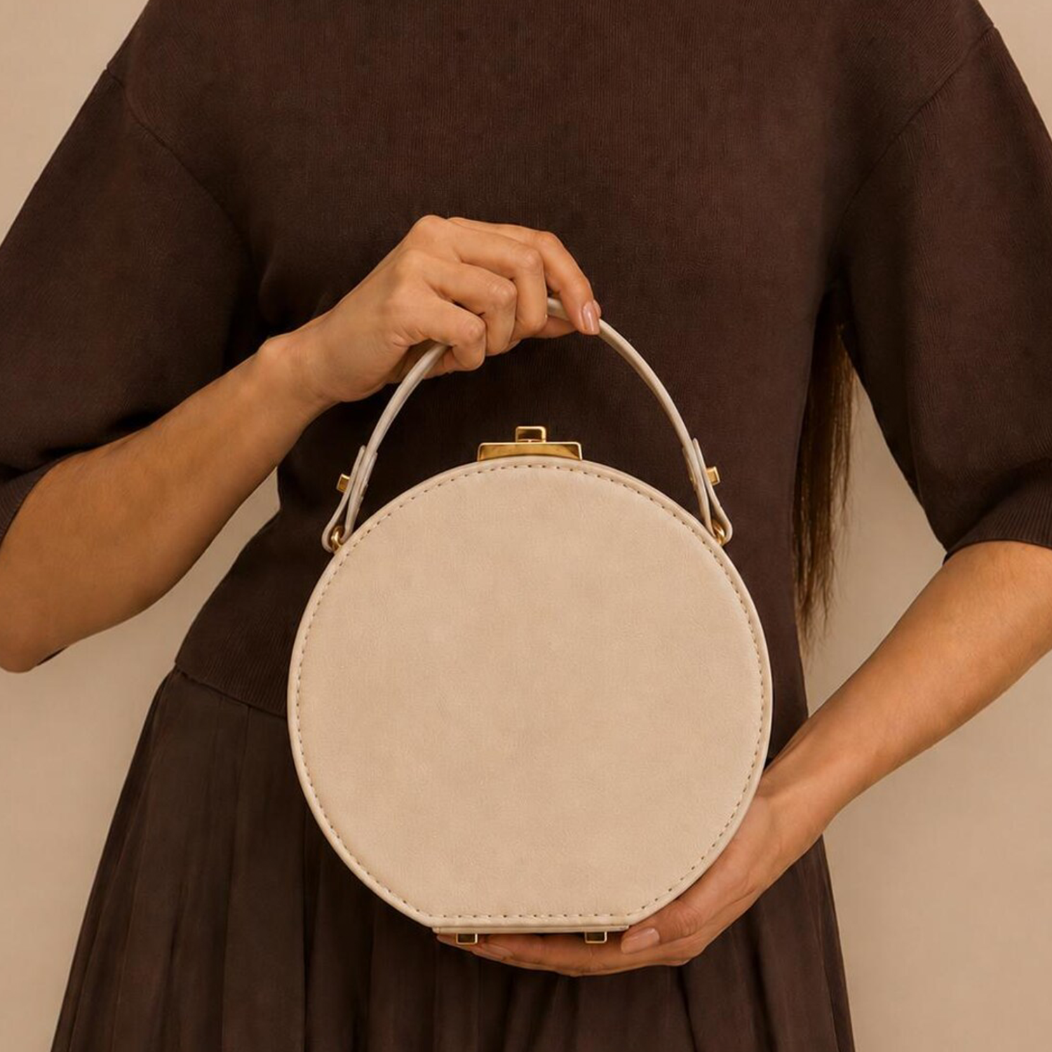 Soft Cream Beige Pebbled Grain Rigid Circular Hatbox Handbag With Curved Fixed Top Handle, Rectangular Gold Twist-Lock Clasp And Protective Base Foot Stud Hardware