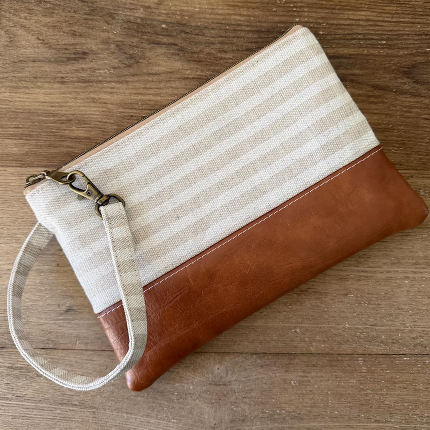 Neutral Horizontal Striped Two-Tone Rectangular Wristlet Clutch With Warm Tan Textured Lower Panel, Antique Top Zipper Hardware And Detachable Fabric Wrist Loop Strap