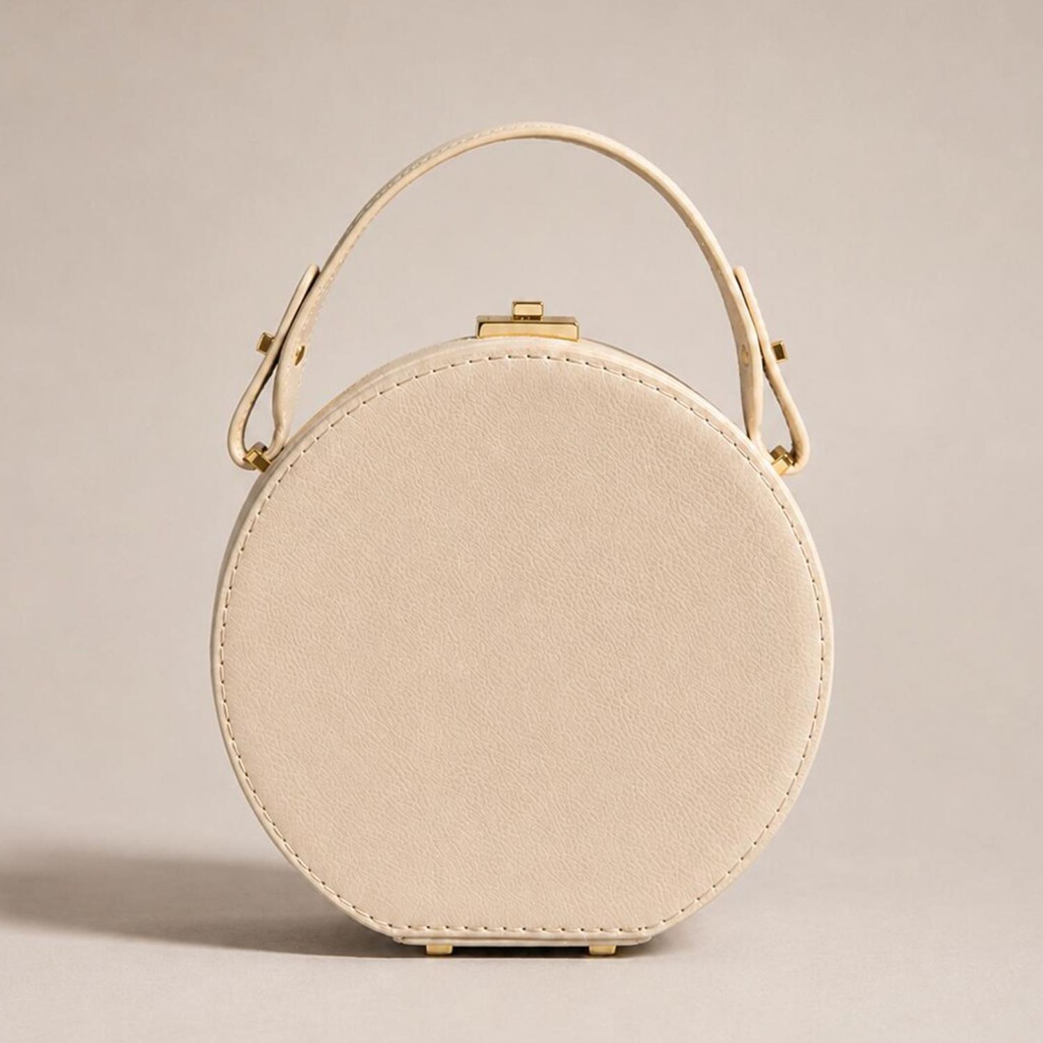 Soft Cream Beige Pebbled Grain Rigid Circular Hatbox Handbag With Curved Fixed Top Handle, Rectangular Gold Twist-Lock Clasp And Protective Base Foot Stud Hardware